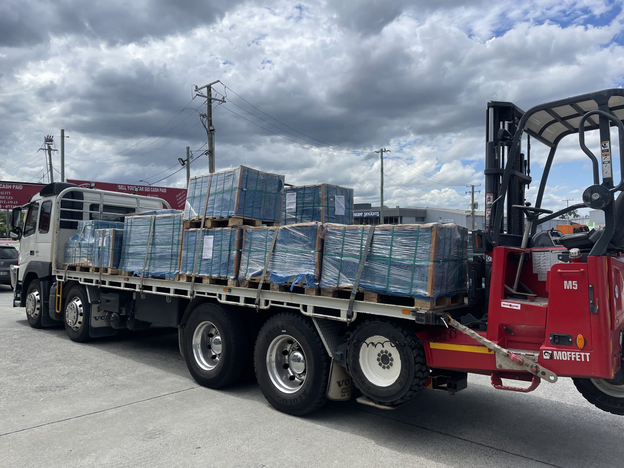 Truck loaded with pallets of pavers and forklift on the back